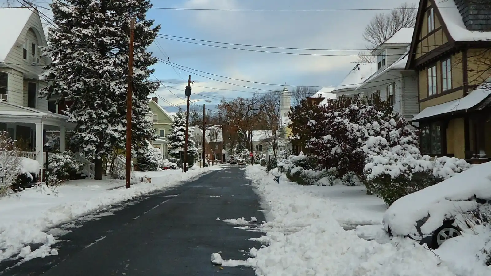 A residential street in Summit, New Jersey, after a snowfall, with the road plowed and snow banked along the sidewalks